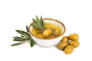 Bir kase taze zeytinyağı ve beyaz arka planda yapraklı zeytin. Cam kasede nefis zeytinyağı. Zeytin yağı şişesi.