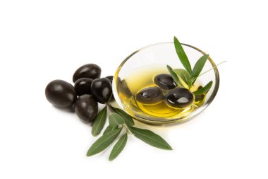 Bir kase taze zeytinyağı ve beyaz arka planda yapraklı zeytin. Cam kasede nefis zeytinyağı. Zeytin yağı şişesi.