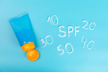 Mavi arka planda güneş kremi. SPF kremi. Güneş koruması. Ultraviyole koruma. Yaz. Dinlenme ve tatil kavramı. Yaz havası. Tasarım. - Model. Tatil. Güzellik.