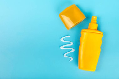 Mavi arka planda güneş kremi. SPF kremi. Güneş koruması. Ultraviyole koruma. Yaz. Dinlenme ve tatil kavramı. Yaz havası. Tasarım. - Model. Tatil. Güzellik.