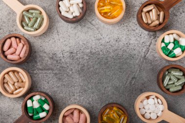 Vitaminler ve takviyeler. Ahşap bir kaşıkta çeşitli vitamin hapları. Taze ve sağlıklı meyveli Multivitaminler. Yiyecek takviyeleri. Düz yatıyordu. Metin için boşluk. Boşluğu kopyala