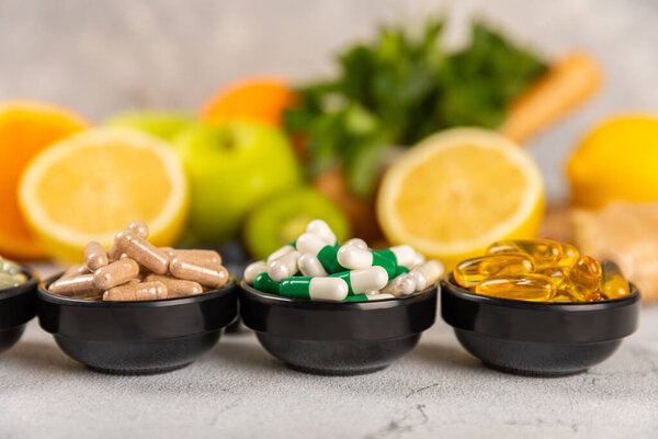 Vitamins and supplements. Variety of vitamin tablets in a jar on a texture background.Multivitamins with fresh and healthy fruits.Food supplements. Flat lay. Space for text.Copy space
