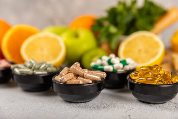 Витамины и добавки. Variety of vitamin tablets in a jar on a texture background.Multivitamin with fresh and healthy fruits.Food supplements. Плоский лежал. Пространство для текстур