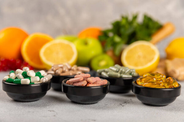 Витамины и добавки. Variety of vitamin tablets in a jar on a texture background.Multivitamin with fresh and healthy fruits.Food supplements. Плоский лежал. Пространство для текстур