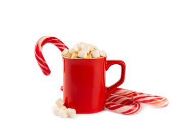 Beyaz bir arka planda izole edilmiş kırmızı bir fincanda marşmelov ve şeker kamışlı sıcak içecek. Sıcak mevsimlik tatiller. Zencefilli Noel kurabiyeli sıcak çikolata. Marşmelov ve baharatlı sıcak çikolata..