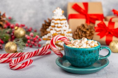 Şekerlemeli sıcak içecek ve şeker kamışı bir dokuma masasında. Sıcak mevsimlik tatiller. Zencefilli Noel kurabiyeleriyle sıcak kakao. Şekerlemeli ve baharatlı sıcak çikolata..