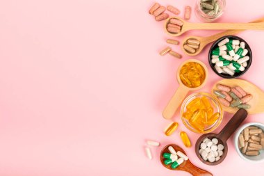 Vitaminler ve takviyeler. Ahşap kaşıklardaki vitamin tabletlerinin dokulu arka planda çeşitliliği. Her gün için multivitamin kompleksi. Besleyici takviyeler. Boşluğu kopyala. Bağışıklık için vitaminler.