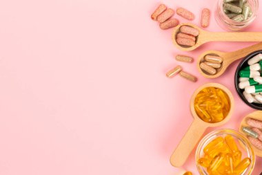 Vitaminler ve takviyeler. Ahşap kaşıklardaki vitamin tabletlerinin dokulu arka planda çeşitliliği. Her gün için multivitamin kompleksi. Besleyici takviyeler. Boşluğu kopyala. Bağışıklık için vitaminler.