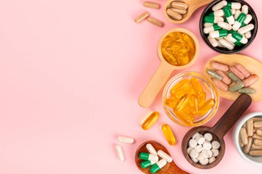 Vitaminler ve takviyeler. Ahşap kaşıklardaki vitamin tabletlerinin dokulu arka planda çeşitliliği. Her gün için multivitamin kompleksi. Besleyici takviyeler. Boşluğu kopyala. Bağışıklık için vitaminler.