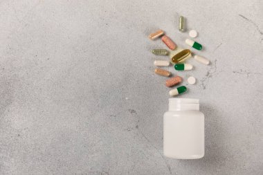 Vitaminler ve takviyeler. Arka planda bulunan bir kavanozdaki vitamin haplarının çeşitliliği. Taze ve sağlıklı meyveli multivitaminler. Yiyecek takviyeleri. Düz yatıyordu. Metin için boşluk. Boşluğu kopyala