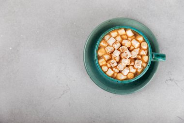 Şekerlemeli sıcak içecek ve desenli masa üzerinde şeker kamışı. Sıcak mevsimlik tatiller. Zencefilli Noel kurabiyeleriyle sıcak kakao. Marşmelov ve baharatla sıcak çikolata..