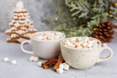 Şekerlemeli sıcak içecek ve desenli masa üzerinde şeker kamışı. Sıcak mevsimlik tatiller. Zencefilli Noel kurabiyeleriyle sıcak kakao. Marşmelov ve baharatla sıcak çikolata..