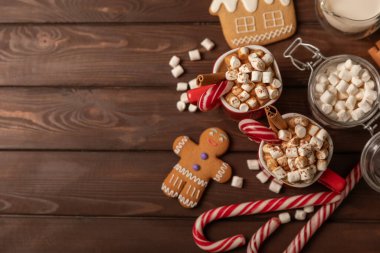 Marşmelovlu sıcak içecek ve kırmızı bir bardakta şeker kamışı. Sıcak mevsimlik tatiller. Zencefilli Noel kurabiyeli sıcak çikolata. Şekerlemeli sıcak çikolata..