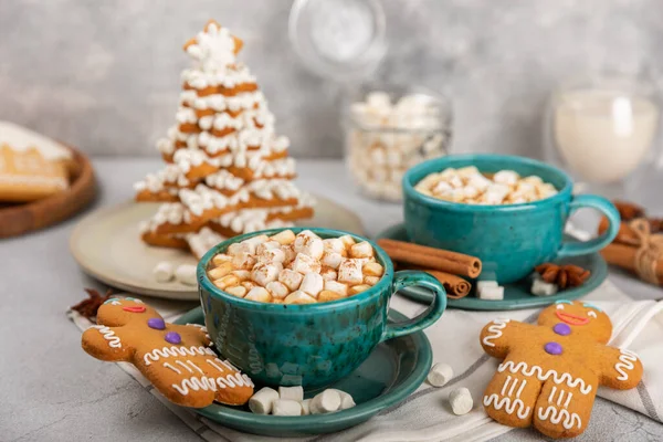 Hot drink with marshmallows and candy cane in cup on texture table.Cozy seasonal holidays.Hot cocoa with gingerbread Christmas cookies.Hot chocolate with marshmallow and spices.Copy space.