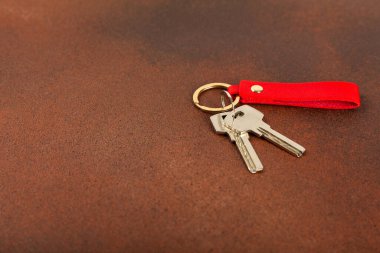 Arka planında anahtarlık olan deri bir anahtarlık. Gayrimenkul ve eve taşınma ya da mülk kiralama kavramları. Mülk almak. Model anahtarlık. Boşluğu kopyala.