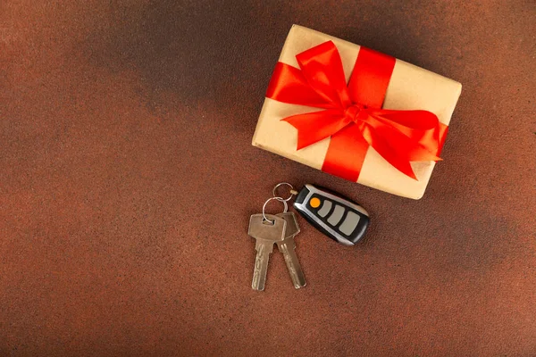 Car key with key fob on a colored background. Buying or renting a car. Car gift. Stylish keychain with car key. Place for text. Copy space.