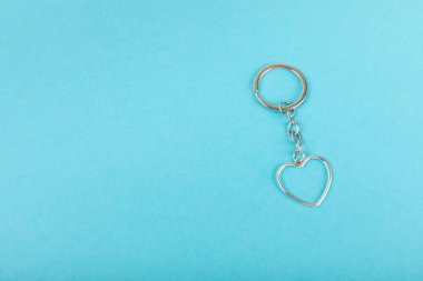 Kalp şeklinde anahtarlık, anahtarlık iyonu renkli bir arka plan. Gayrimenkul ve eve taşınma ya da mülk kiralama kavramları. Mülk almak. Model anahtarlık. Boşluğu kopyala.