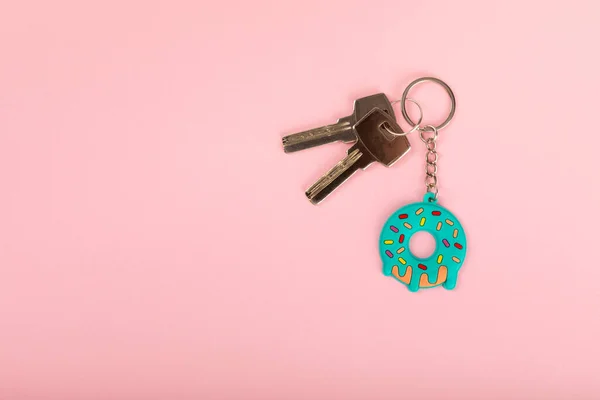 Donut shaped keychain with key ring on a colored background. Concepts for real estate and moving home or renting property. Buying a property. Mock-up keychain.Copy space.
