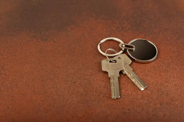 Keychain with key ring isolated on a colored background. Concepts for real estate and moving home or renting property. Buying a property. Mock-up keychain.Copy space.