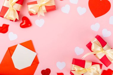 Sevgililer Günü konsepti. Sevgililer Günü geçmişi. Hediyeler, mumlar, konfeti, zarf pembe arka planda. Düz, üst manzara, kopyalama alanı. Sevgililer Günü kutlaması.