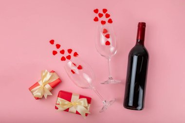 Sevgililer Günü konsepti. Sevgililer Günü özgeçmişi. Hediyeler, mumlar, konfeti, zarf - kartpostal, şeker, bardak, şarap ve pembe arka planda bir buket gül. Flatley. Sevgililer Günü kutlaması.