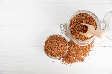 Ahşap kaplamalı bir kasede çiğ karabuğday. Buğday taneleri, yulaf lapası, tahıllar, tabakta çiğ karabuğday. Sağlıklı yiyecekler. Yulaf. Diyet olsun. Organik mısır gevreği. Metin için boşluk. Boşluğu kopyala.