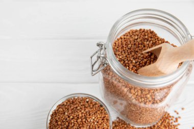 Ahşap kaplamalı bir kasede çiğ karabuğday. Buğday taneleri, yulaf lapası, tahıllar, tabakta çiğ karabuğday. Sağlıklı yiyecekler. Yulaf. Diyet olsun. Organik mısır gevreği. Metin için boşluk. Boşluğu kopyala.