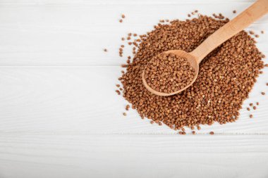 Ahşap kaplamalı bir kasede çiğ karabuğday. Buğday taneleri, yulaf lapası, tahıllar, tabakta çiğ karabuğday. Sağlıklı yiyecekler. Yulaf. Diyet olsun. Organik mısır gevreği. Metin için boşluk. Boşluğu kopyala.