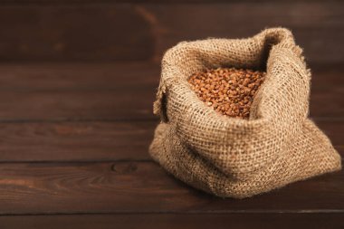 Ahşap kaplamalı bir kasede çiğ karabuğday. Buğday taneleri, yulaf lapası, tahıllar, tabakta çiğ karabuğday. Sağlıklı yiyecekler. Yulaf. Diyet olsun. Organik mısır gevreği. Metin için boşluk. Boşluğu kopyala.