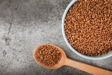 Ahşap kaplamalı bir kasede çiğ karabuğday. Buğday taneleri, yulaf lapası, tahıllar, tabakta çiğ karabuğday. Sağlıklı yiyecekler. Yulaf. Diyet olsun. Organik mısır gevreği. Metin için boşluk. Boşluğu kopyala.