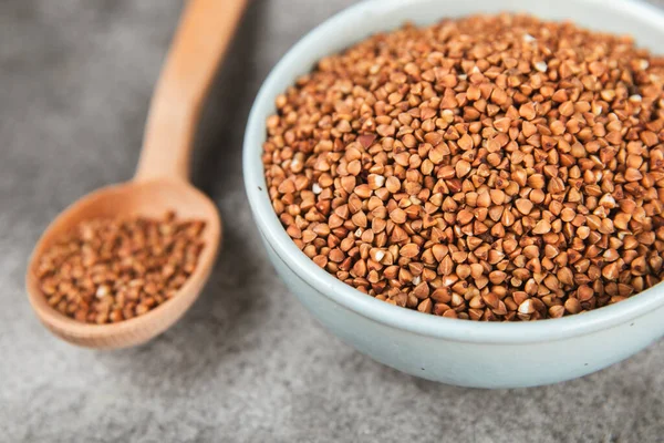 Ahşap kaplamalı bir kasede çiğ karabuğday. Buğday taneleri, yulaf lapası, tahıllar, tabakta çiğ karabuğday. Sağlıklı yiyecekler. Yulaf. Diyet olsun. Organik mısır gevreği. Metin için boşluk. Boşluğu kopyala.