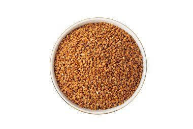 Beyaz arka planda izole edilmiş bir kasede çiğ karabuğday. Buğday taneleri, yulaf lapası, tahıllar, tabakta çiğ karabuğday. Sağlıklı yiyecekler. Yulaf. Diyet olsun. Organik mısır gevreği