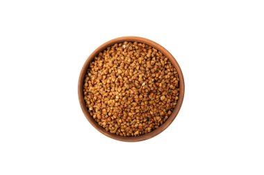 Beyaz arka planda izole edilmiş bir kasede çiğ karabuğday. Buğday taneleri, yulaf lapası, tahıllar, tabakta çiğ karabuğday. Sağlıklı yiyecekler. Yulaf. Diyet olsun. Organik mısır gevreği