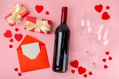 Sevgililer Günü konsepti. Sevgililer Günü özgeçmişi. Hediyeler, mumlar, konfeti, zarf - kartpostal, şeker, bardak, şarap ve pembe arka planda bir buket gül. Flatley. Sevgililer Günü kutlaması.