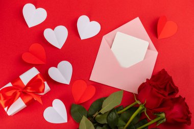 Sevgililer Günü konsepti. Sevgililer Günü özgeçmişi. Hediyeler, mumlar, konfeti, zarf, şekerler, bardaklar, şarap ve renkli bir arka planda bir buket gül. Flatley. Sevgililer Günü kutlaması.