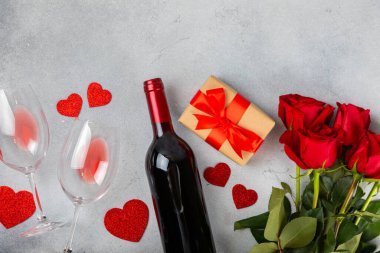 Sevgililer Günü konsepti. Sevgililer Günü geçmişi. Hediyeler, mumlar, konfetiler, zarf - kartpostal, şekerler, bardaklar, şarap ve mermer arka planda bir buket gül. Düz, üst görünüm.