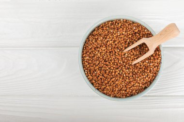 Arka planda desenli bir kasede çiğ karabuğday. Buğday taneleri, yulaf lapası, tahıllar, tabakta çiğ karabuğday. Sağlıklı yiyecekler. Yulaf. Diyet olsun. Organik mısır gevreği. Metin için boşluk. Boşluğu kopyala.