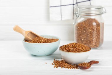 Arka planda desenli bir kasede çiğ karabuğday. Buğday taneleri, yulaf lapası, tahıllar, tabakta çiğ karabuğday. Sağlıklı yiyecekler. Yulaf. Diyet olsun. Organik mısır gevreği. Metin için boşluk. Boşluğu kopyala.