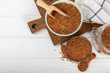 Arka planda desenli bir kasede çiğ karabuğday. Buğday taneleri, yulaf lapası, tahıllar, tabakta çiğ karabuğday. Sağlıklı yiyecekler. Yulaf. Diyet olsun. Organik mısır gevreği. Metin için boşluk. Boşluğu kopyala.