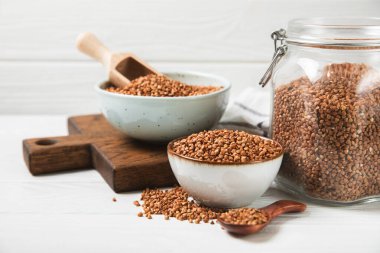 Arka planda desenli bir kasede çiğ karabuğday. Buğday taneleri, yulaf lapası, tahıllar, tabakta çiğ karabuğday. Sağlıklı yiyecekler. Yulaf. Diyet olsun. Organik mısır gevreği. Metin için boşluk. Boşluğu kopyala.