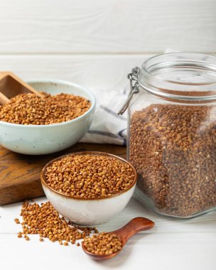 Arka planda desenli bir kasede çiğ karabuğday. Buğday taneleri, yulaf lapası, tahıllar, tabakta çiğ karabuğday. Sağlıklı yiyecekler. Yulaf. Diyet olsun. Organik mısır gevreği. Metin için boşluk. Boşluğu kopyala.