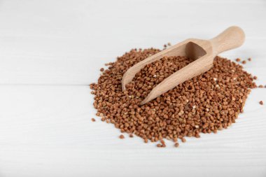 Arka planda desenli bir kasede çiğ karabuğday. Buğday taneleri, yulaf lapası, tahıllar, tabakta çiğ karabuğday. Sağlıklı yiyecekler. Yulaf. Diyet olsun. Organik mısır gevreği. Metin için boşluk. Boşluğu kopyala.