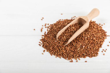 Arka planda desenli bir kasede çiğ karabuğday. Buğday taneleri, yulaf lapası, tahıllar, tabakta çiğ karabuğday. Sağlıklı yiyecekler. Yulaf. Diyet olsun. Organik mısır gevreği. Metin için boşluk. Boşluğu kopyala.