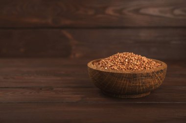 Arka planda desenli bir kasede çiğ karabuğday. Buğday taneleri, yulaf lapası, tahıllar, tabakta çiğ karabuğday. Sağlıklı yiyecekler. Yulaf. Diyet olsun. Organik mısır gevreği. Metin için boşluk. Boşluğu kopyala.