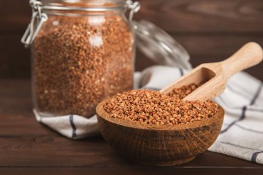 Arka planda desenli bir kasede çiğ karabuğday. Buğday taneleri, yulaf lapası, tahıllar, tabakta çiğ karabuğday. Sağlıklı yiyecekler. Yulaf. Diyet olsun. Organik mısır gevreği. Metin için boşluk. Boşluğu kopyala.