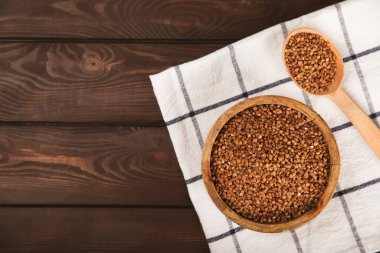 Arka planda desenli bir kasede çiğ karabuğday. Buğday taneleri, yulaf lapası, tahıllar, tabakta çiğ karabuğday. Sağlıklı yiyecekler. Yulaf. Diyet olsun. Organik mısır gevreği. Metin için boşluk. Boşluğu kopyala.