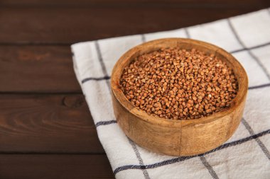 Arka planda desenli bir kasede çiğ karabuğday. Buğday taneleri, yulaf lapası, tahıllar, tabakta çiğ karabuğday. Sağlıklı yiyecekler. Yulaf. Diyet olsun. Organik mısır gevreği. Metin için boşluk. Boşluğu kopyala.