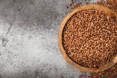 Arka planda desenli bir kasede çiğ karabuğday. Buğday taneleri, yulaf lapası, tahıllar, tabakta çiğ karabuğday. Sağlıklı yiyecekler. Yulaf. Diyet olsun. Organik mısır gevreği. Metin için boşluk. Boşluğu kopyala.