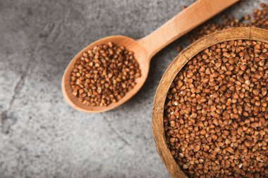 Arka planda desenli bir kasede çiğ karabuğday. Buğday taneleri, yulaf lapası, tahıllar, tabakta çiğ karabuğday. Sağlıklı yiyecekler. Yulaf. Diyet olsun. Organik mısır gevreği. Metin için boşluk. Boşluğu kopyala.