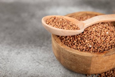 Arka planda desenli bir kasede çiğ karabuğday. Buğday taneleri, yulaf lapası, tahıllar, tabakta çiğ karabuğday. Sağlıklı yiyecekler. Yulaf. Diyet olsun. Organik mısır gevreği. Metin için boşluk. Boşluğu kopyala.